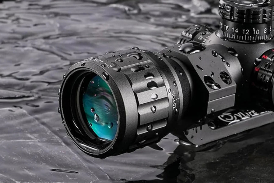 The image features a CVLIFE rifle scope with a black matte finish, sitting in a pool of water. The lens area of the scope is focused on with visible droplets of water on the surface, emphasizing its water-resistant design. 